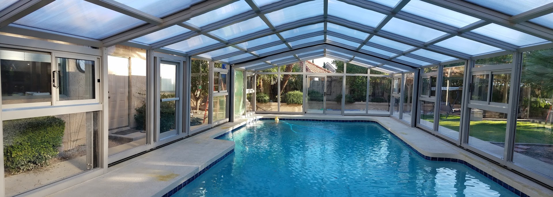 High profile retractable pool enclosure that is classified as a permanent structure and subject to many regulations